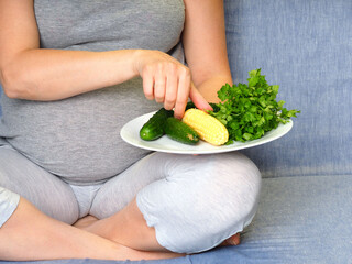 pregnant woman eating fresh green vegetables