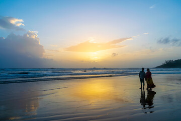 Fototapeta na wymiar silhouette of a couple walking on the beach, Baga Beach, Goa, India