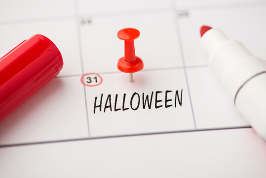 Overhead photo of label date 31 october inscription halloween red pin and marker isolated on the calendar background