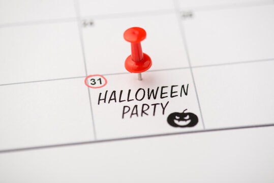 Above photo of label date 31 october with inscription halloween party red pin and pumpkin isolated on the calendar background