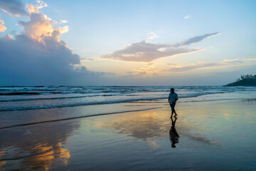 Sunset walk at Baga Beach, Goa, India - obrazy, fototapety, plakaty