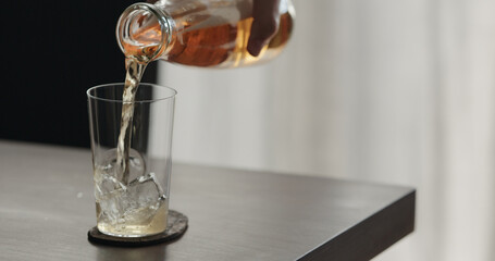 closeup pour mate drink in a tumbler glass on walnut table with copy space