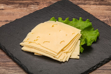 Sliced yellow cheese over board
