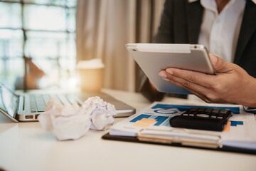 Fototapeta premium Business documents on office table with laptop and digital tablet and calculator on graph financial.