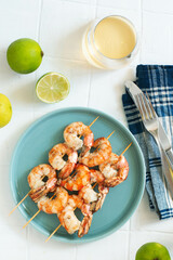 Grilled prawns in a light blue plate. Blue towels and white background