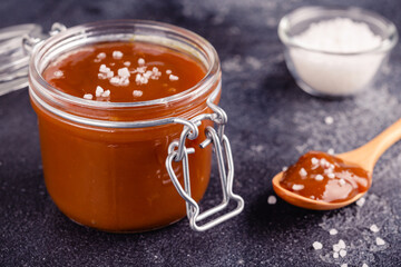 Glass jar with tasty delicious salted caramel