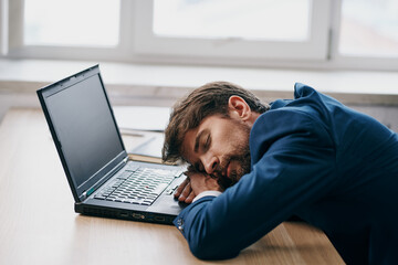 tired business man in front of laptop in office