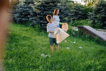 A group of girls with children at sunset are engaged in garbage collection in the park....