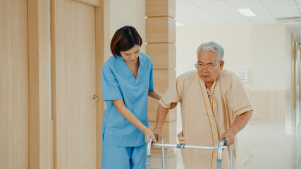 Young Asian woman nurse caregiver assistance encourage take care her senior patient explain with positive keep comforting for practice walker in hospital ward, Hospital environment concept.
