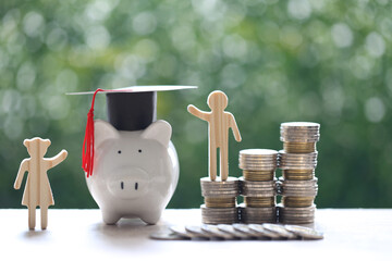 Graduation hat on piggy bank with stack of coins money on natural green background, Saving money...