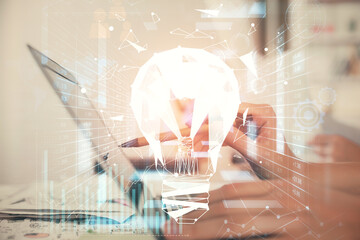 Double exposure of woman hands typing on computer and light bulb drawing. Idea concept.