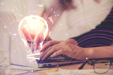 Double exposure of woman hands typing on computer and light bulb drawing. Idea concept.