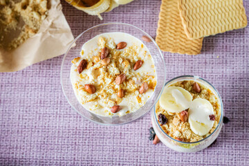 Delicious and healthy yogurt dessert with banana, biscuits and nuts.