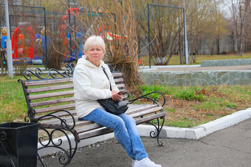 Senior Woman Relaxing On Park Bench.