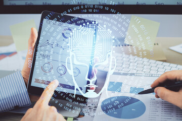 Double exposure of man's hand holding and using a digital device and brain hologram drawing. Data concept.