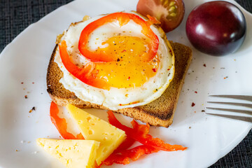 Delicious and healthy breakfast. Scrambled eggs on a toaster with cheese and tomatoes.