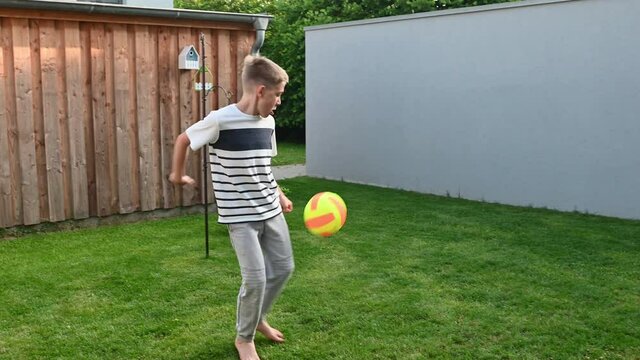 4K video of happy little boy practice his feint and tricks competition with ball at backyard during summer holidays