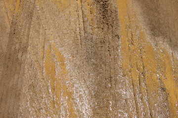 Traces de pneus sur une route boueuse en terre humide de couleur rouille