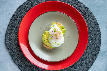 Breakfast of bread toast with avocado and poached egg