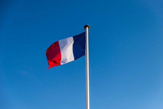 Drapeau français  flottant au vent sur un fond de ciel bleu