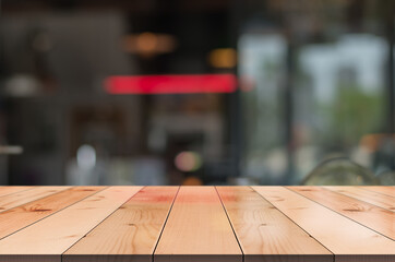 Obraz premium Empty wooden table top with lights bokeh on blur restaurant background.