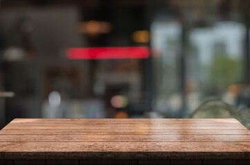 Empty wooden table top with lights bokeh on blur restaurant background.