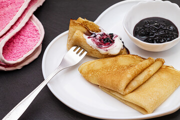 Delicious catlets on a plate with sauce of sour cream and greens close-up.