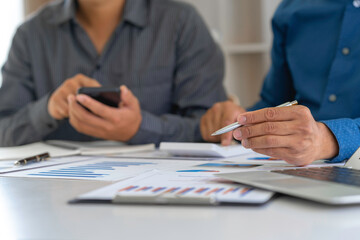 Business people discussing working and presenting the charts and graphs showing the results of their successful teamwork, the discussion aimed at reaching an agreement, Business concept.