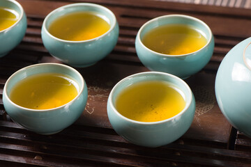 cups of green tea and teapot on  tea tray 