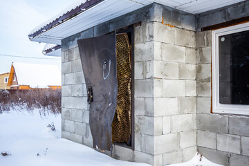 Aerated concrete block building with broken lock and door frame damaged