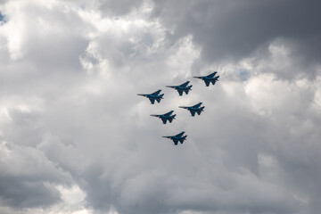 Combat aircraft are flying against the background of the sky. Cloudy sky. Beautiful fighters.