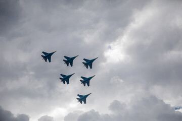 Combat aircraft are flying against the background of the sky. Cloudy sky. Beautiful fighters.