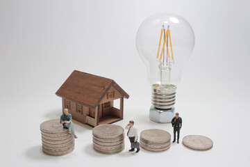 A Light bulb with coins and house, figure model. Power energy concept