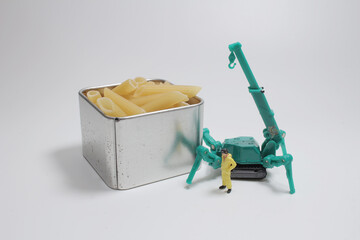 a Conceptual diorama image of miniature figures shaping fusilli pasta