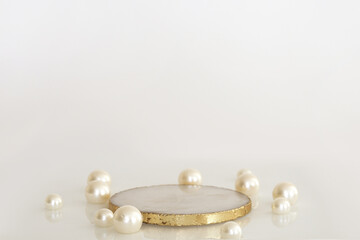 Marble podium with gold and pearls on the white background. Podium for product, cosmetic presentation. Creative mock up. Pedestal or platform for beauty products.