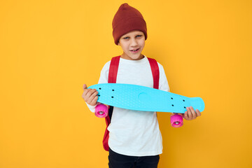 Cool smiling boy in a white sweater skateboard entertainment studio lifestyle