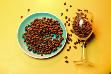 pine nuts scattered on a plate and in a transparent glass on a yellow background