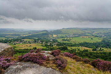 From the top of Curbar Edge out across fields and meadows on misty, grey summer morning in...