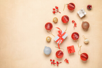 Beautiful Christmas composition. Red and gold Christmas balls, gift boxes and decorations on a beige concrete background. Top view, flat lay.