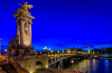 Pont Alexandre III (Alexander the third bridge) over river Seine in Paris, France.  Night cityscape of Paris. Architecture and landmarks of Paris.