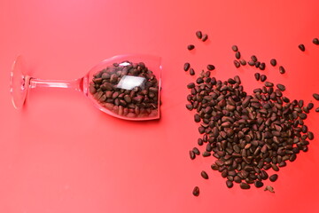 sprinkled pine nuts in a transparent glass on a red background