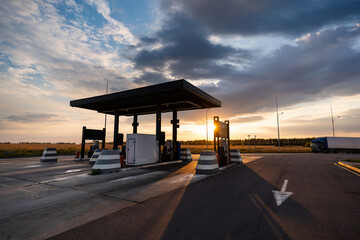 Modern self service gas station against the backdrop of a dramatic sunset sky