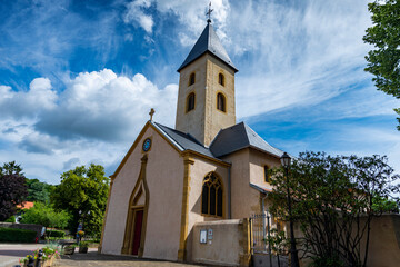 Fototapeta na wymiar Belle petite église traditionnelle Saint-Rémy de Scy à Scy-Chazelles sur un ciel bleu du 11è siècle