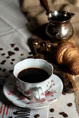 cup of coffe with croissant and cezve