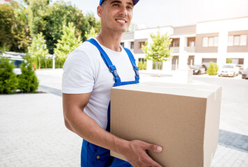 Young delivery man hold a cardboard box in his hands