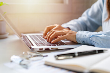 Young woman sitting at living room and working on laptop at home