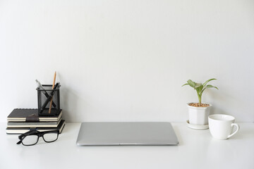 Modern and stylish workspace mock up with laptop and desk office supplies with white background and copy space