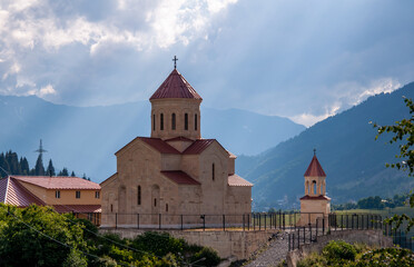 Church in Mestia in sunbeams on the background of mountains