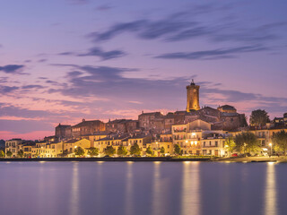 Fototapeta na wymiar morning twilight and last street lights of city Marta on lake Bolsena in Italy