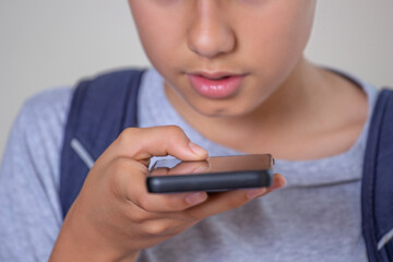 Teenage boy hold smart phone talking through microphone, using cell phone voice recognition...